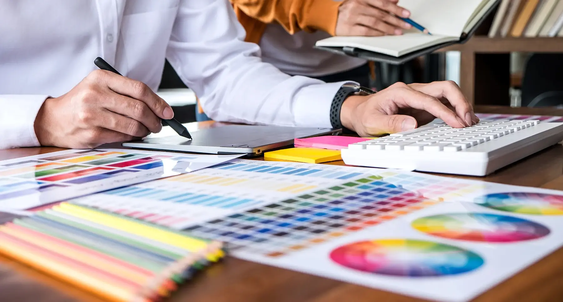 Graphistes travaillant sur des nuanciers de couleurs et une tablette graphique